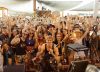 Crowd gathered at Joshua Tree Music Festival under bright desert festival structures.
