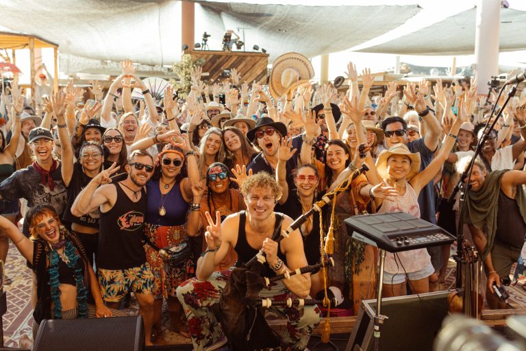 Crowd gathered at Joshua Tree Music Festival under bright desert festival structures.