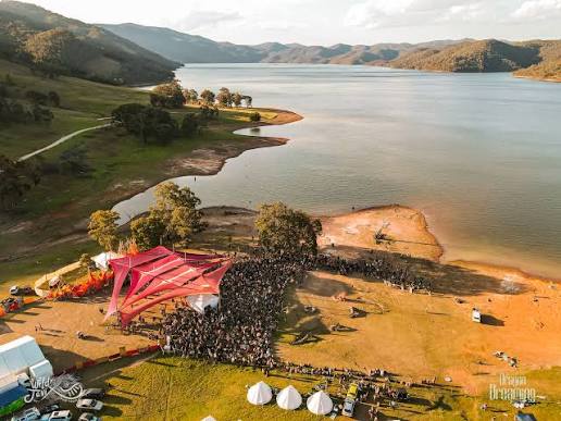 Aerial view of a lakeside festival stage and crowd