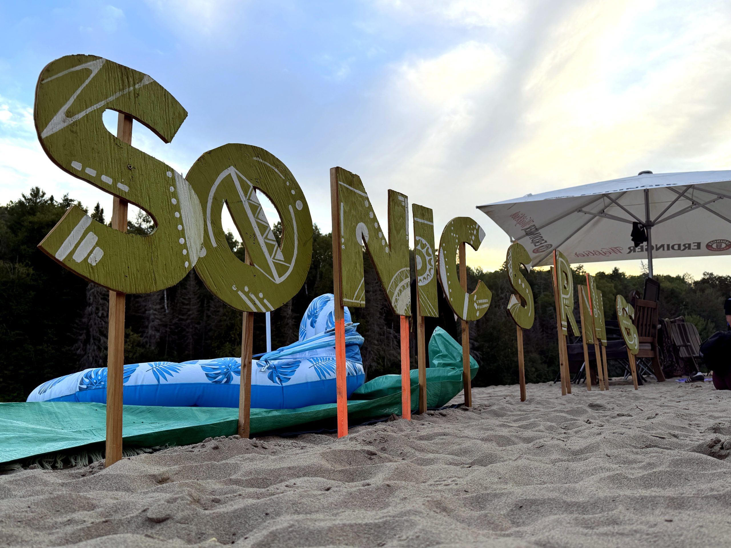 A World Worth Making 2 The Sonic Springs sign on the beach at dusk