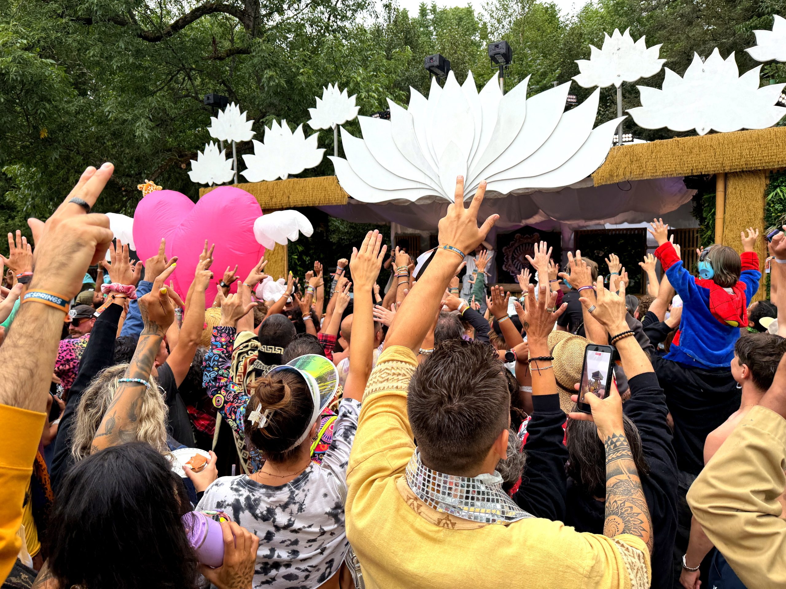 A World Worth Making 8 Hands raised in front of the Lotus stage during a daytime set